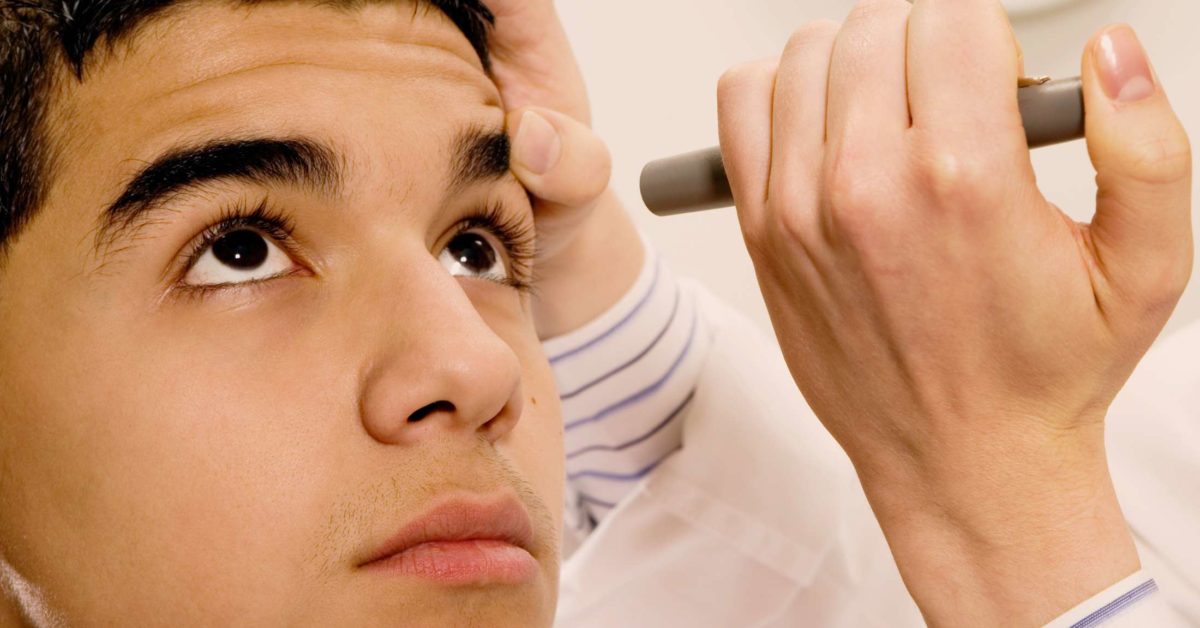 Provider uses light to assess pupillary response.